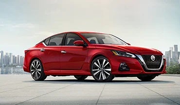 2023 Nissan Altima in red with city in background illustrating last year's 2022 model in Moses Nissan of Huntington in Huntington WV